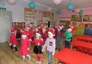 Dzieci biorą udział w zabawie ruchowej "Robimy świąteczne porządki".